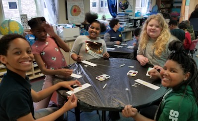 Fourth grade students sitting at a table making bookmarks