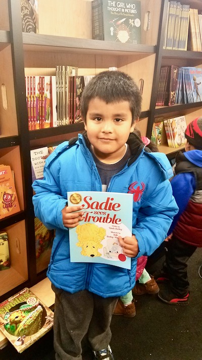 Young reader on the Read-N-Roll bookmobile with ‘Sadie Sees Trouble’