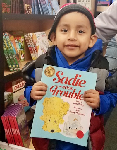 Another young reader on the Read-N-Roll bookmobile with ‘Sadie Sees Trouble’